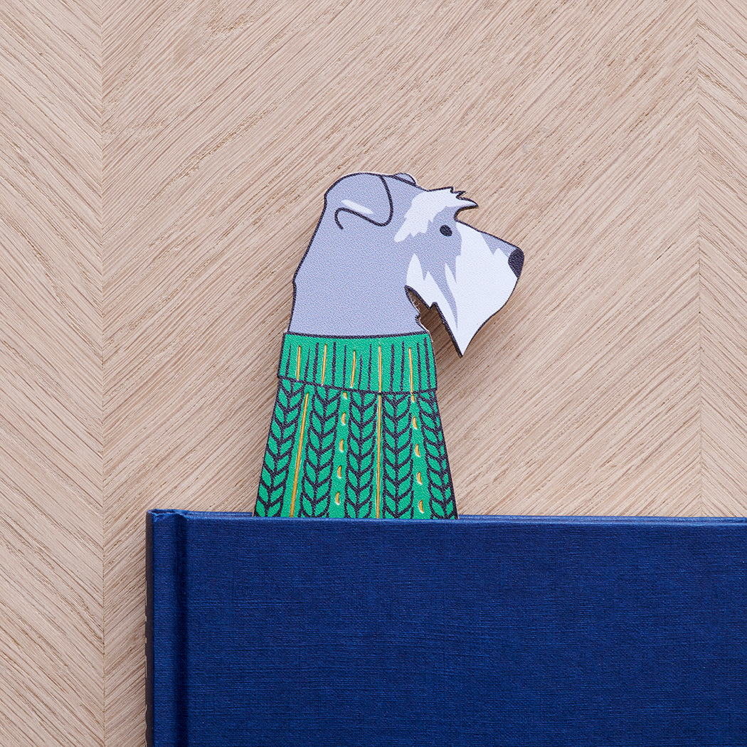 Salt & Pepper Schnauzer bookmark peeking out of navy book — illustrated dog in green jumper, vegan PU leather bookmark by Sweet William Designs
