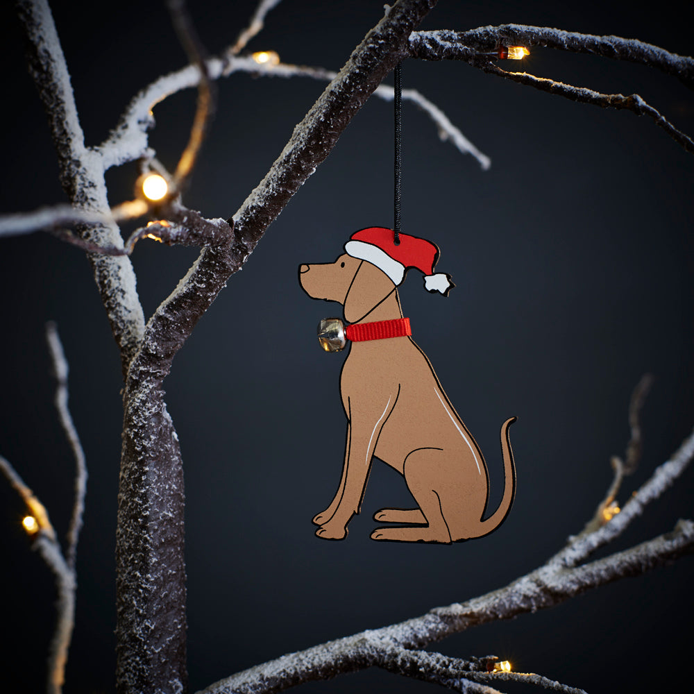 Vizsla Christmas tree decoration hanging on lit winter tree — wooden dog decoration with Father Christmas hat and jingle bell collar by Sweet William Designs