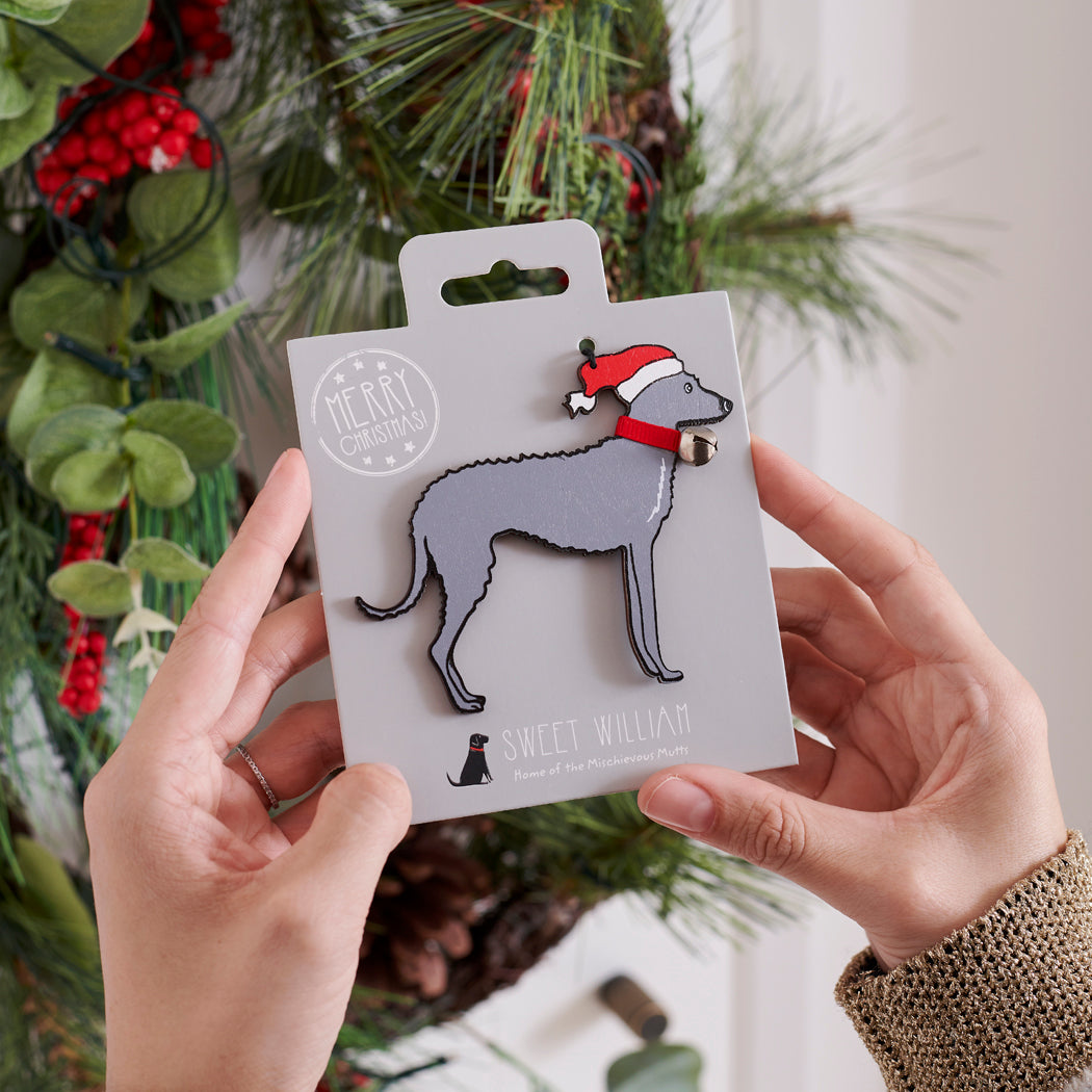 Lurcher Christmas tree decoration held in hands on backing card — Father Christmas hat and jingle bell collar, dog lover gift by Sweet William Designs