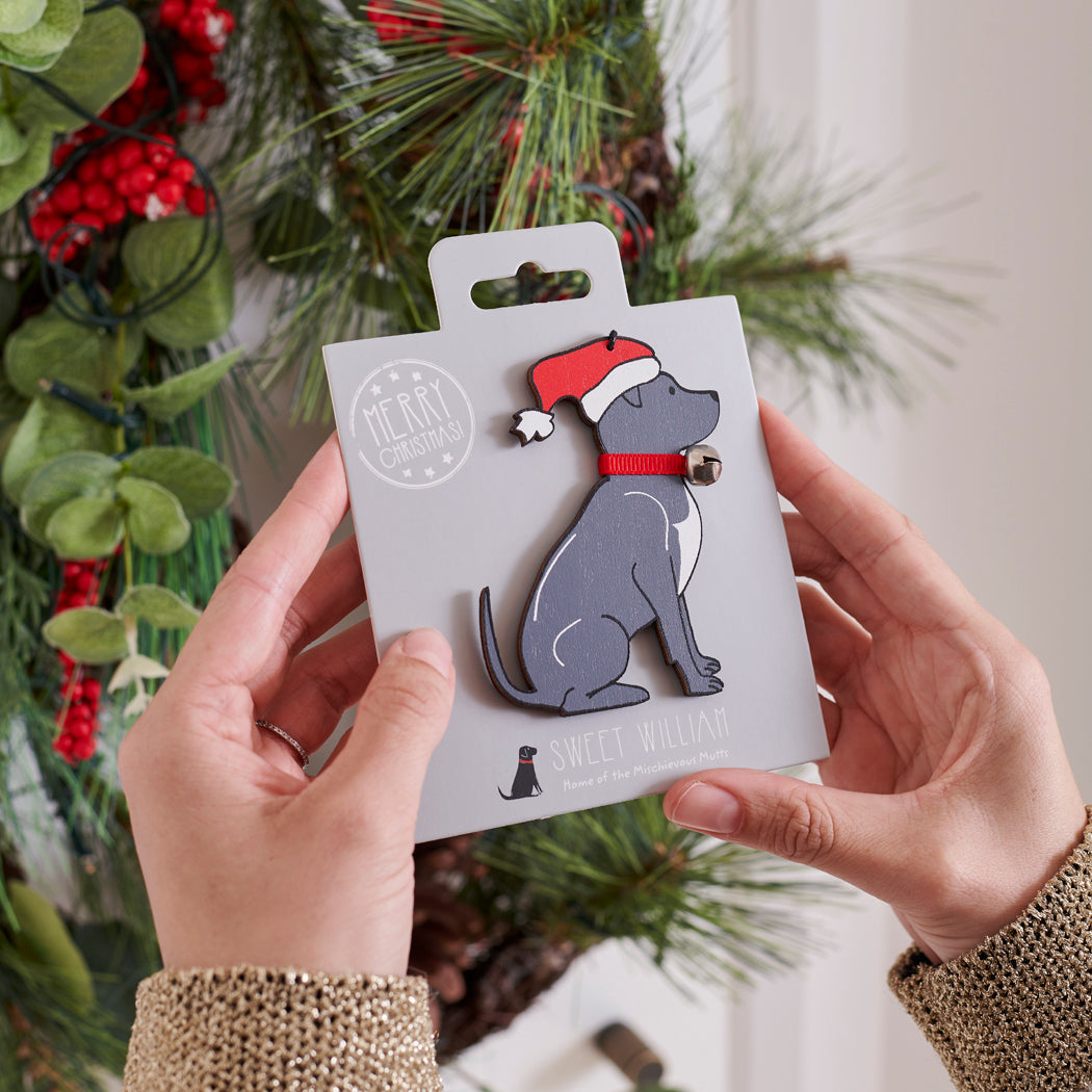 Staffie Christmas tree decoration held in hands on backing card — Father Christmas hat and jingle bell collar, dog lover gift by Sweet William Designs