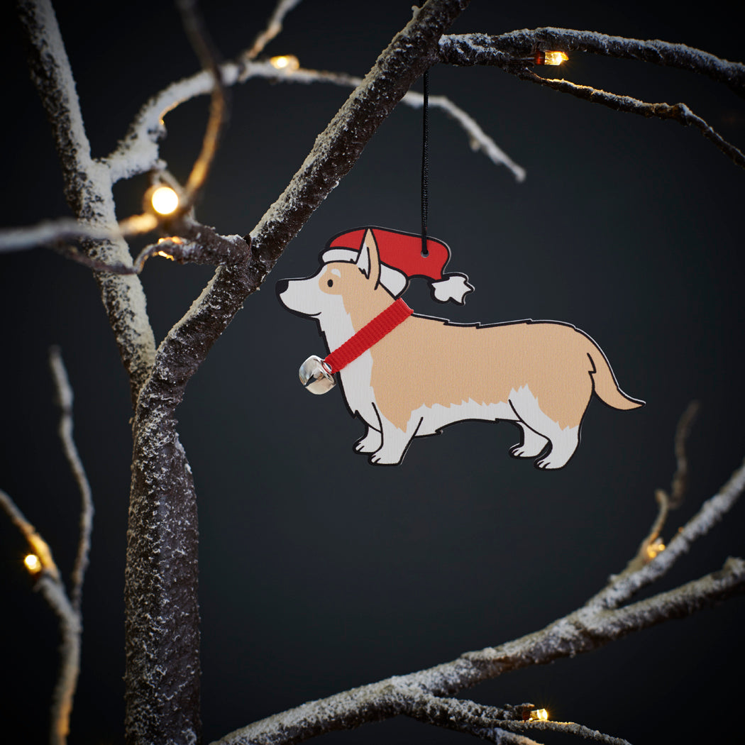 Corgi Christmas tree decoration hanging on lit winter tree — wooden dog decoration with Father Christmas hat and jingle bell collar by Sweet William Designs