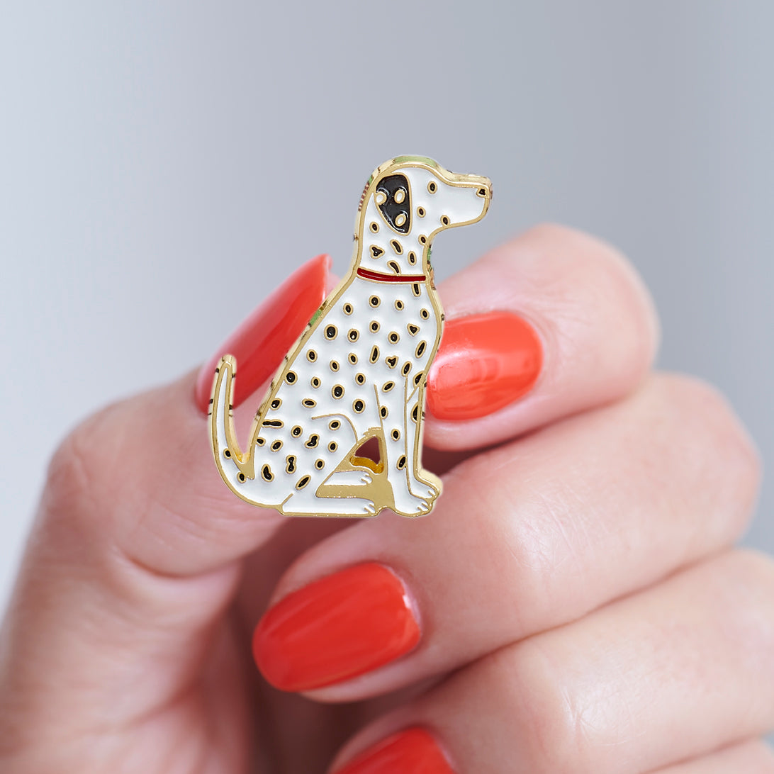 Close-up of a Dalmatian enamel pin held in hand, showing the detailed Dalmatian illustration by Sweet William Designs