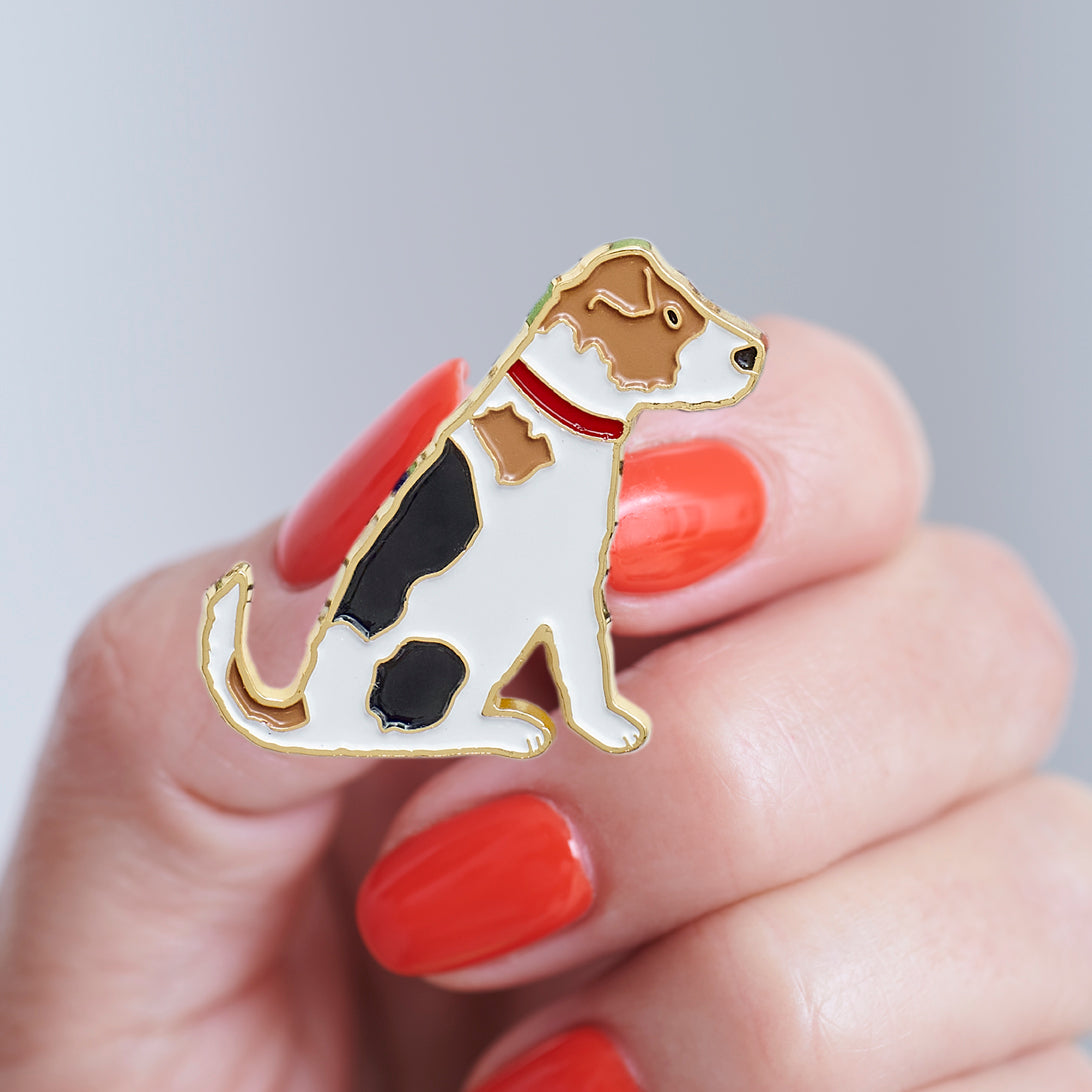 Close-up of a Jack Russell enamel pin held in hand, showing the detailed Jack Russell illustration by Sweet William Designs
