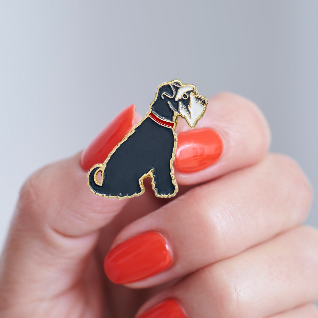 Close-up of a Grey Schnauzer enamel pin held in hand, showing the detailed Schnauzer illustration by Sweet William Designs
