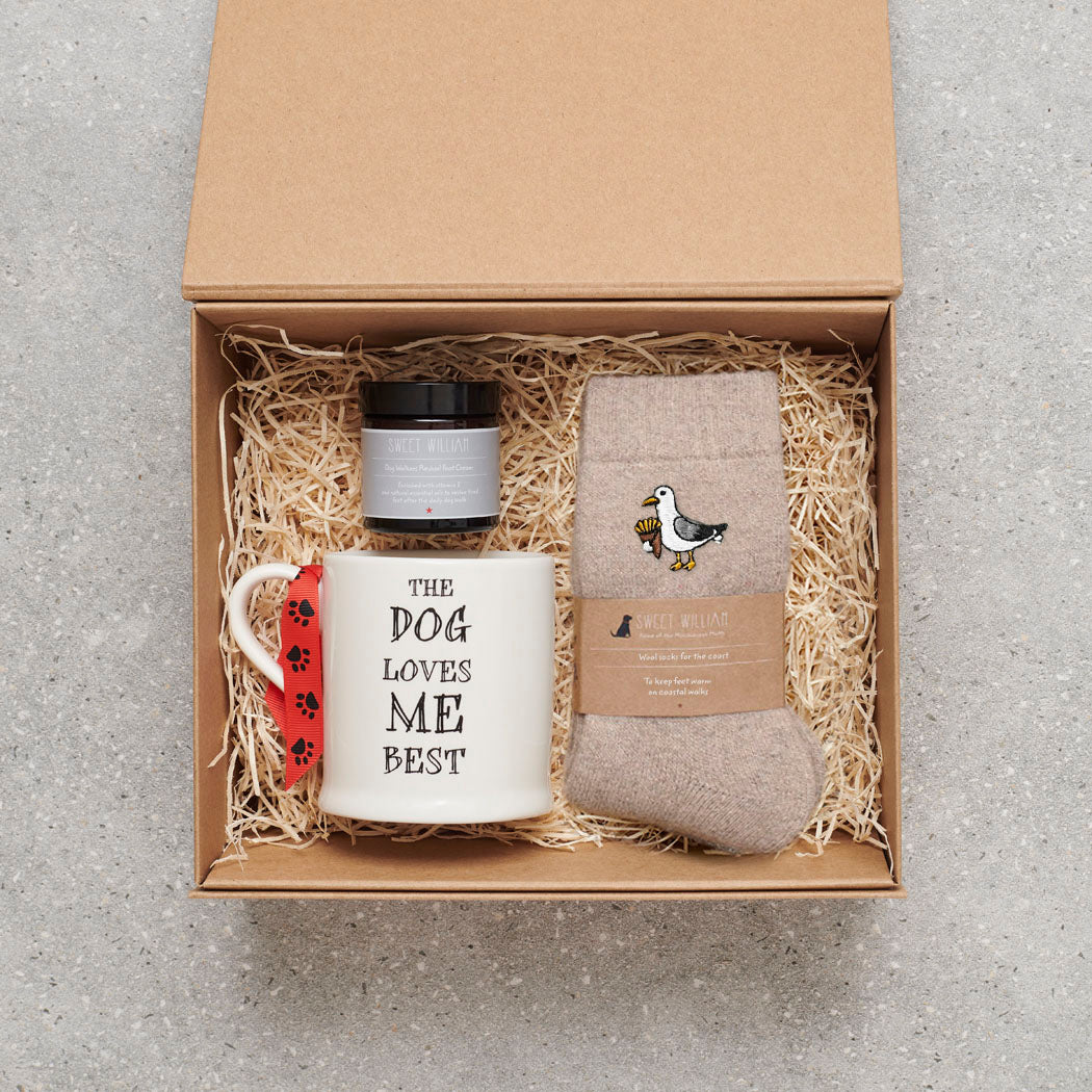 Seagull wool socks in a gift hamper with Sweet William Designs 'The Dog Loves Me Best' mug and Dog Walker Revival foot cream — thoughtful coastal gift set for beach lovers