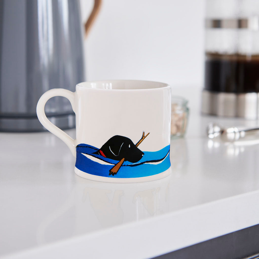 Swimming Black Labrador mug in a kitchen setting — ceramic boxed mug, perfect Labrador owner gift
