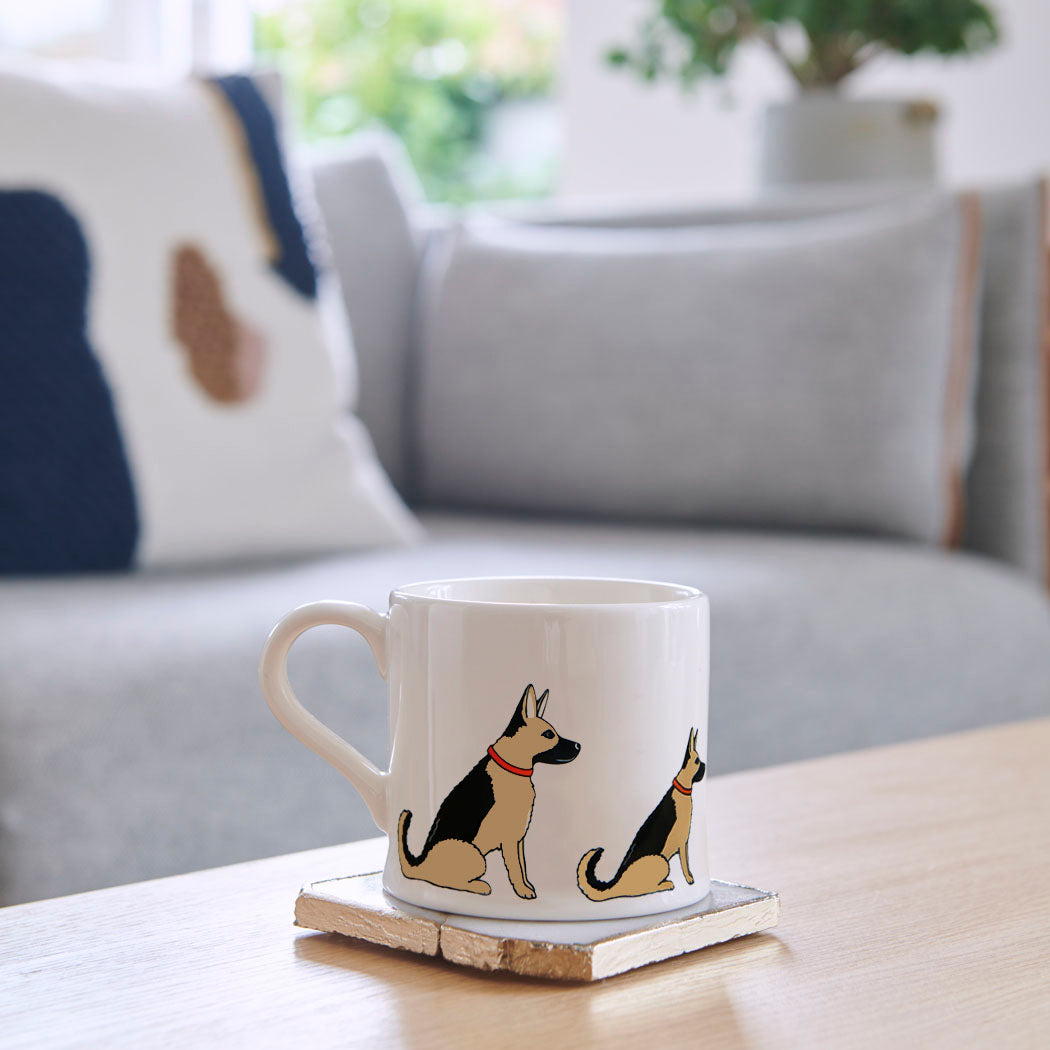 Sweet William German Shepherd Mug on a coffee table — illustrated German Shepherd repeat pattern ceramic mug