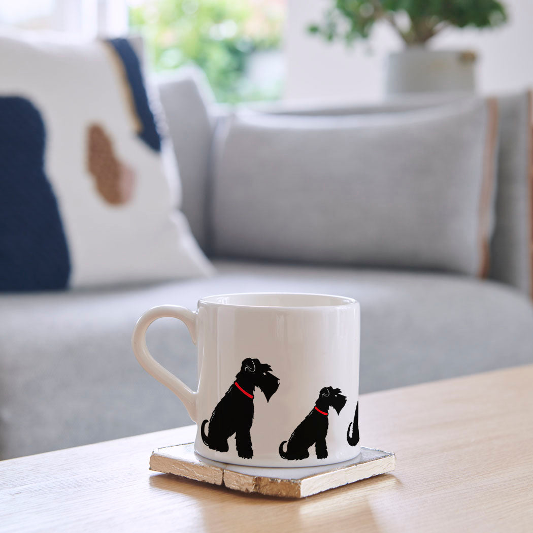 Sweet William Black Schnauzer Mug on a coffee table — illustrated Black Schnauzer repeat pattern ceramic mug