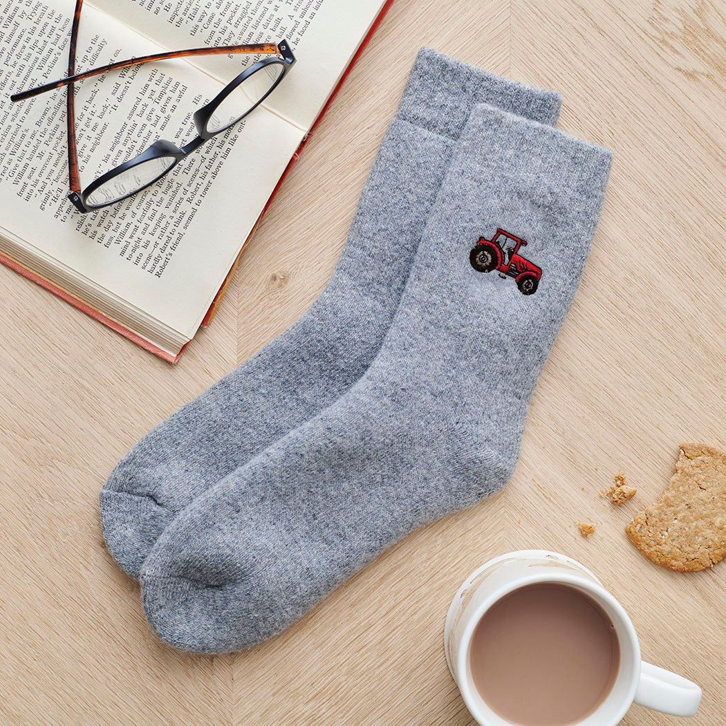 Tractor embroidered wool socks laid flat with book, glasses and cup of tea — cosy country-inspired gift by Sweet William Designs