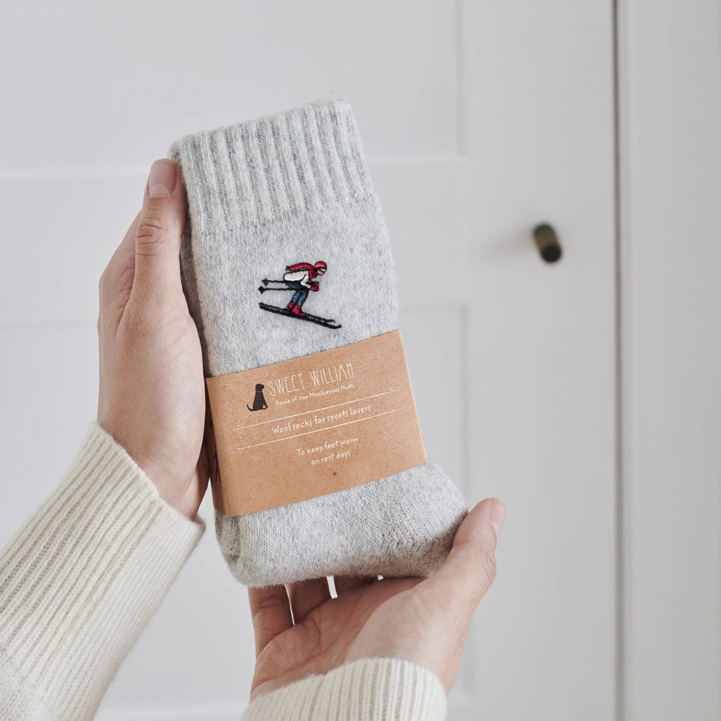 Ski wool socks held in hands with Sweet William Designs branded band — soft wool blend ski lover gift