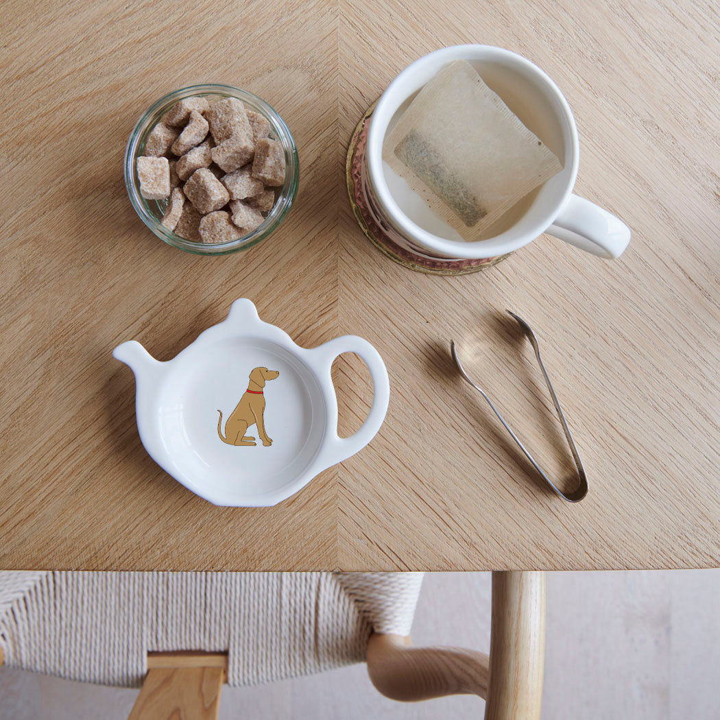 White teapot-shaped Vizsla teabag dish with a golden-brown dog illustration and red collar, beside a mug, sugar cubes and sugar tongs