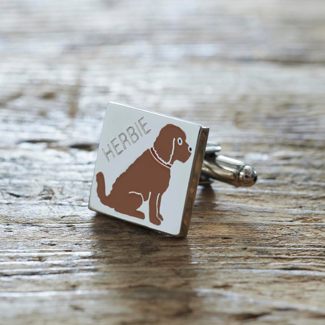 Close-up of personalised Chocolate Cockapoo / Labradoodle cufflink engraved with name on rustic wood — silver-plated gift for Cockapoo owners