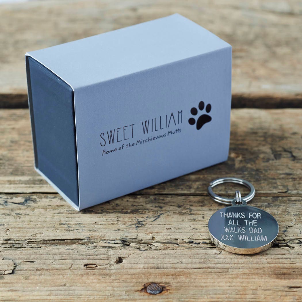Personalised dog ID tag with engraved message alongside Sweet William Designs gift box — personalised dog tag, thoughtful dog lover gift