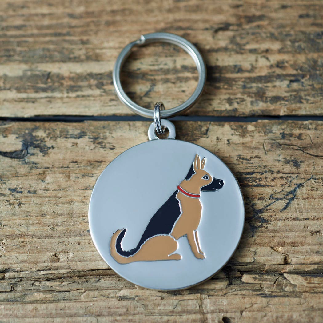 Close-up of German Shepherd dog ID tag — silver-plated brass with illustrated German Shepherd design, personalised dog tag by Sweet William Designs