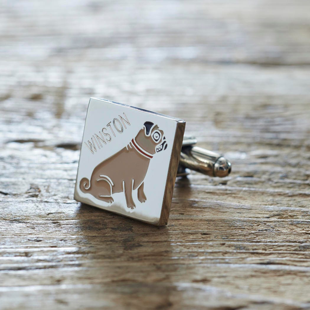 Close-up of personalised Pug cufflink engraved with name on rustic wood — silver-plated gift for Pug owners