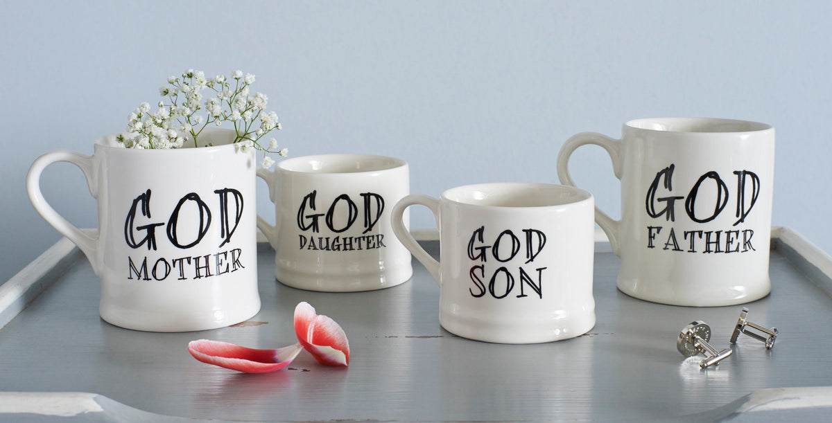 Ceramic Godmother, Godfather, God Daughter and God Son mugs displayed together with flower petals and silver cufflinks, showing full collection by Sweet William Designs