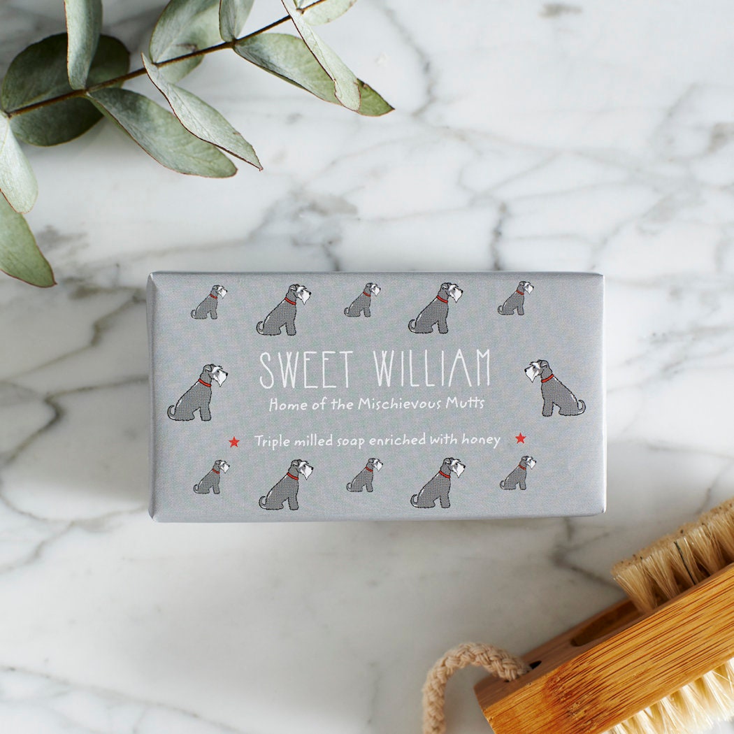 Close-up of Grey Schnauzer soap packaging — Sweet William triple milled soap enriched with honey, featuring an illustrated Grey Schnauzer repeat pattern