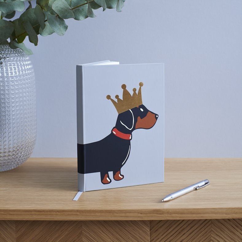 Dachshund A5 notebook standing upright on desk — illustrated sausage dog with gold foil crown, perfect gift for Dachshund lovers