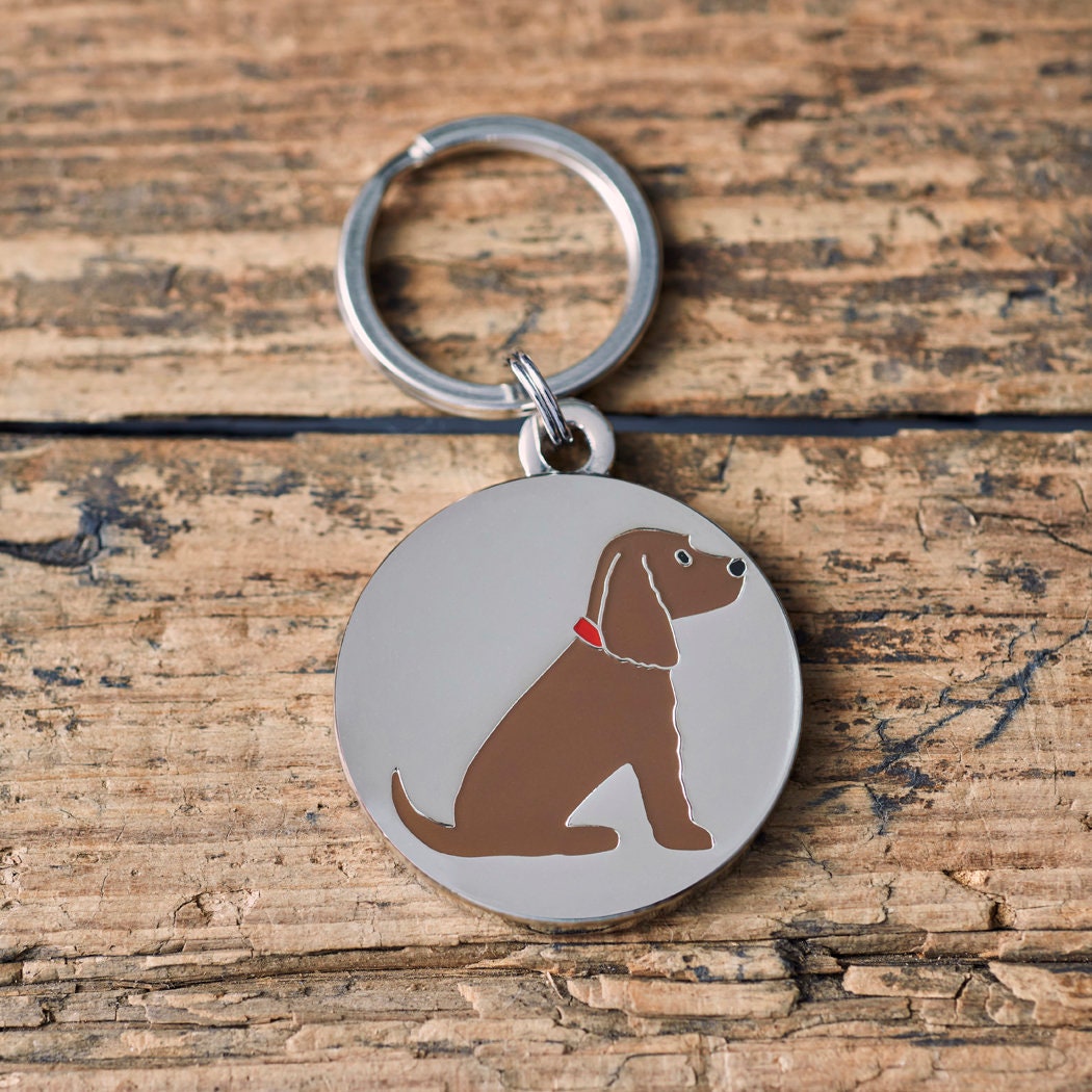 Close-up of Chocolate Cocker Spaniel personalised dog tag — silver-plated brass with illustrated Cocker Spaniel design, personalised dog lover gift by Sweet William Designs
