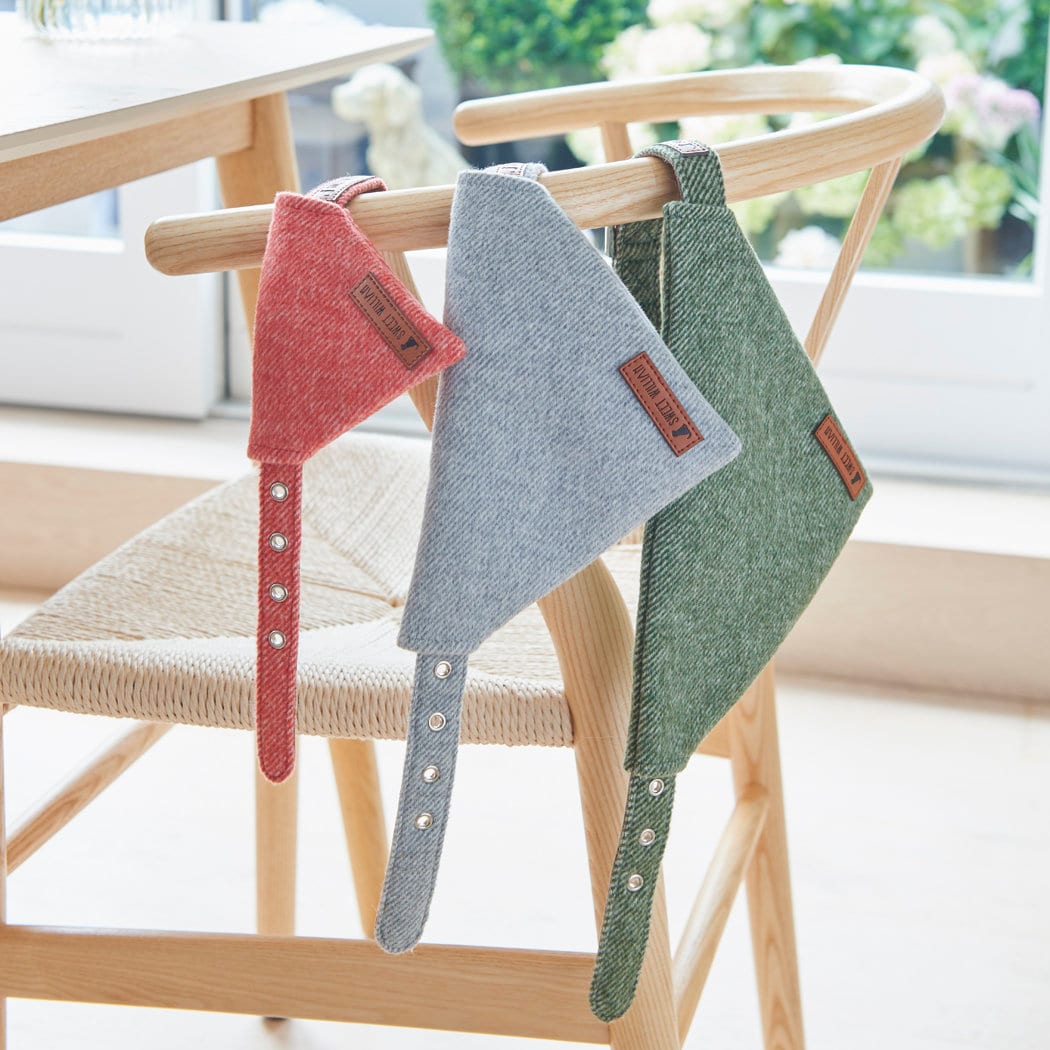 Orange, grey and green tweed dog bandanas threaded onto matching collars and displayed together