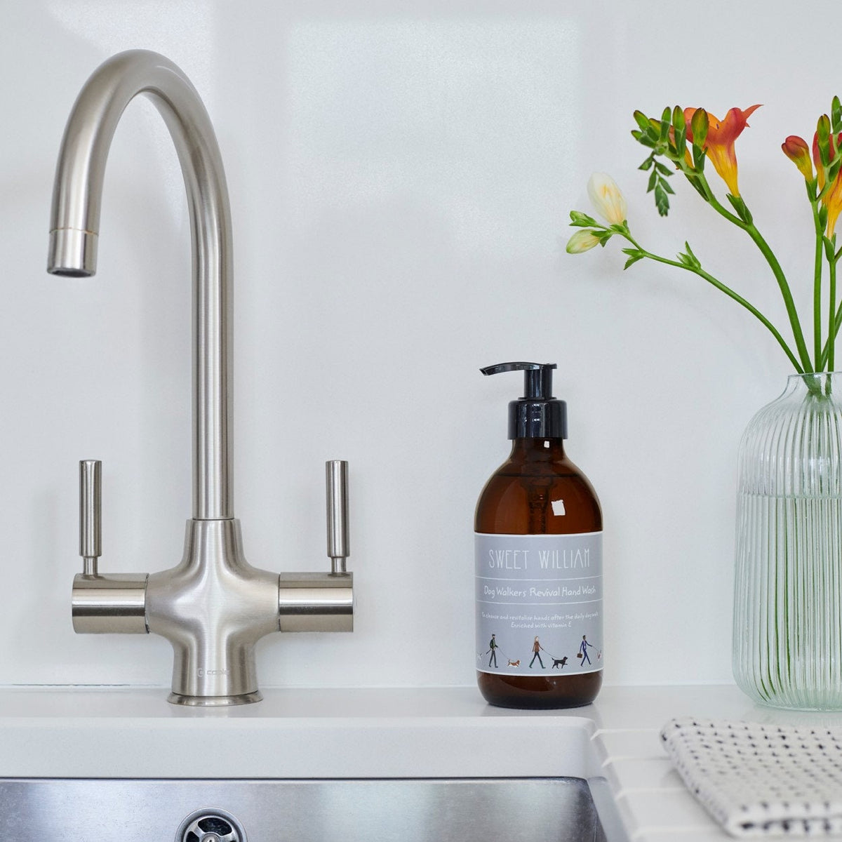 Dog Walkers Revival Hand Wash on kitchen sink surface with flowers — natural hand wash, thoughtful gift for dog walkers by Sweet William Designs