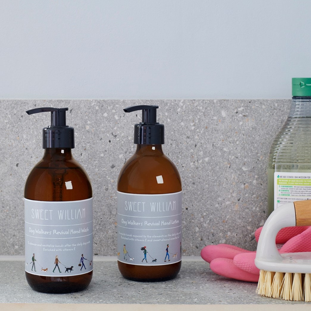 Dog Walkers Revival Hand Wash and Hand Lotion on kitchen worktop with rubber gloves and scrubbing brush — practical hand care gift set by Sweet William Designs