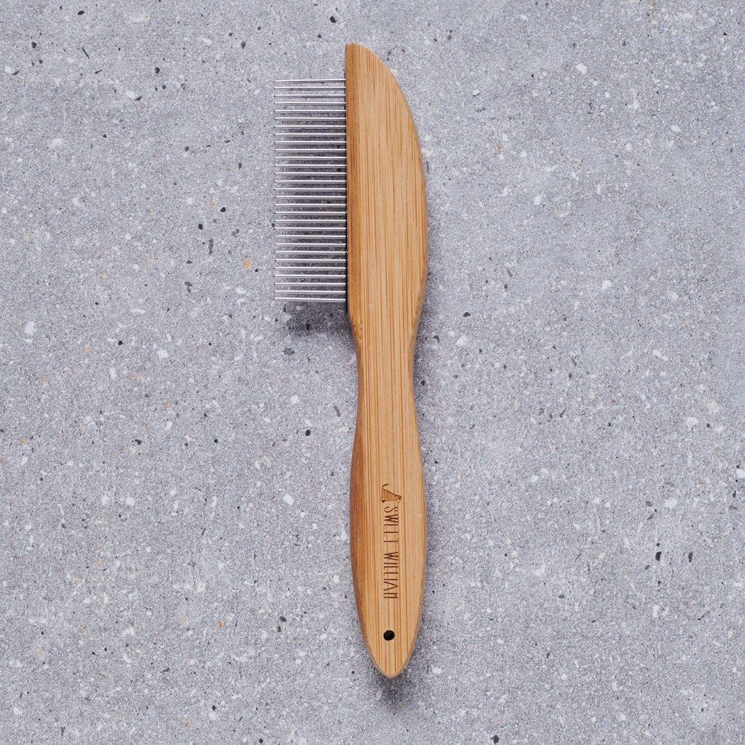 Bamboo dog comb with metal teeth on grey stone surface — dog grooming comb by Sweet William Designs