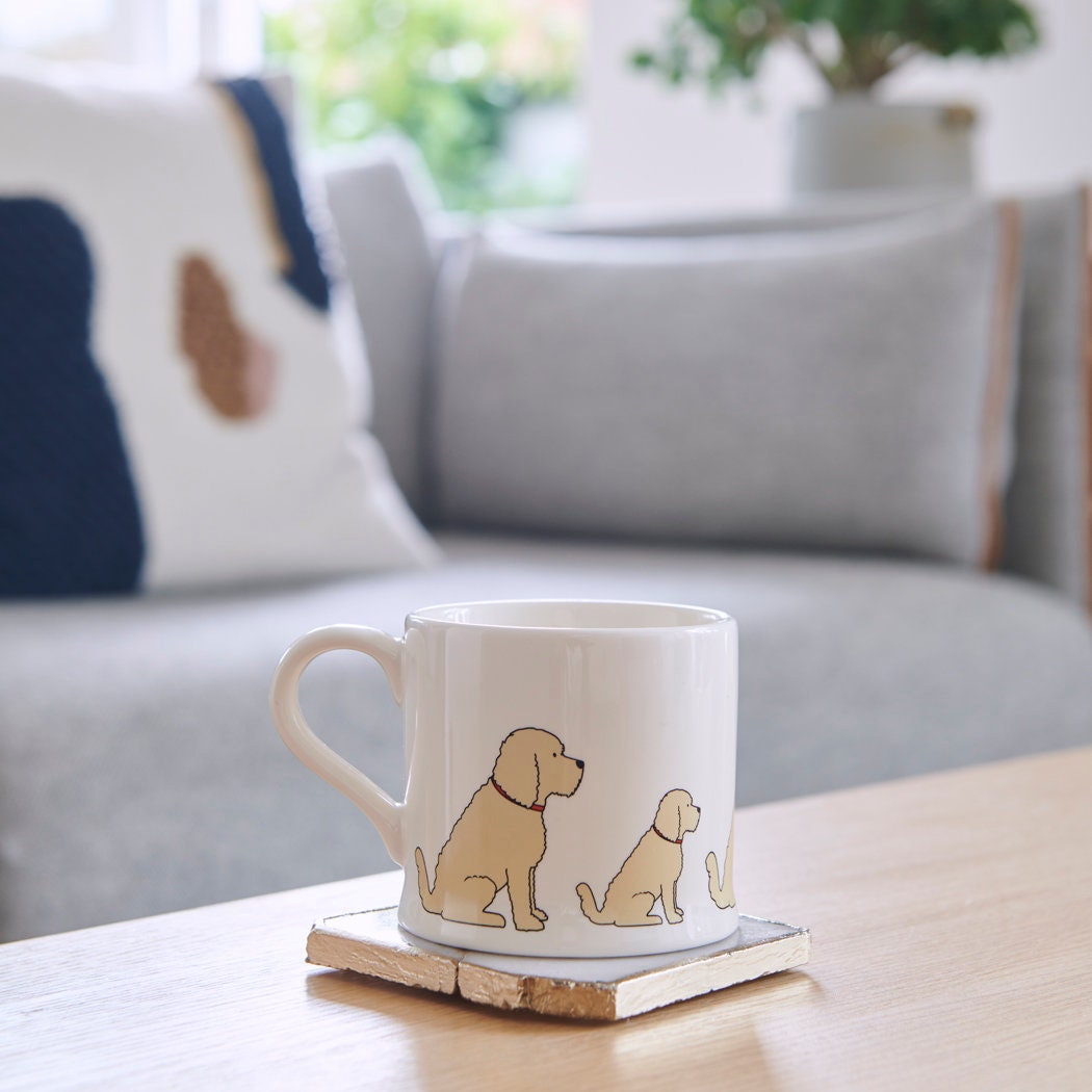 Sweet William Apricot Cockapoo Mug on a coffee table — illustrated Cockapoo repeat pattern ceramic mug