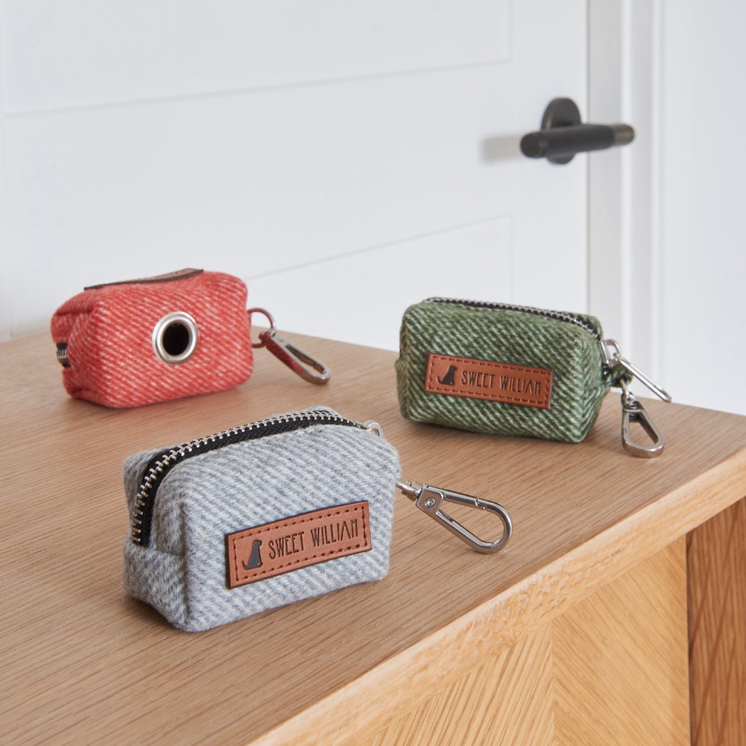Grey, green and orange tweed poo bag holders by Sweet William, with the orange holder turned to show where the bags come out