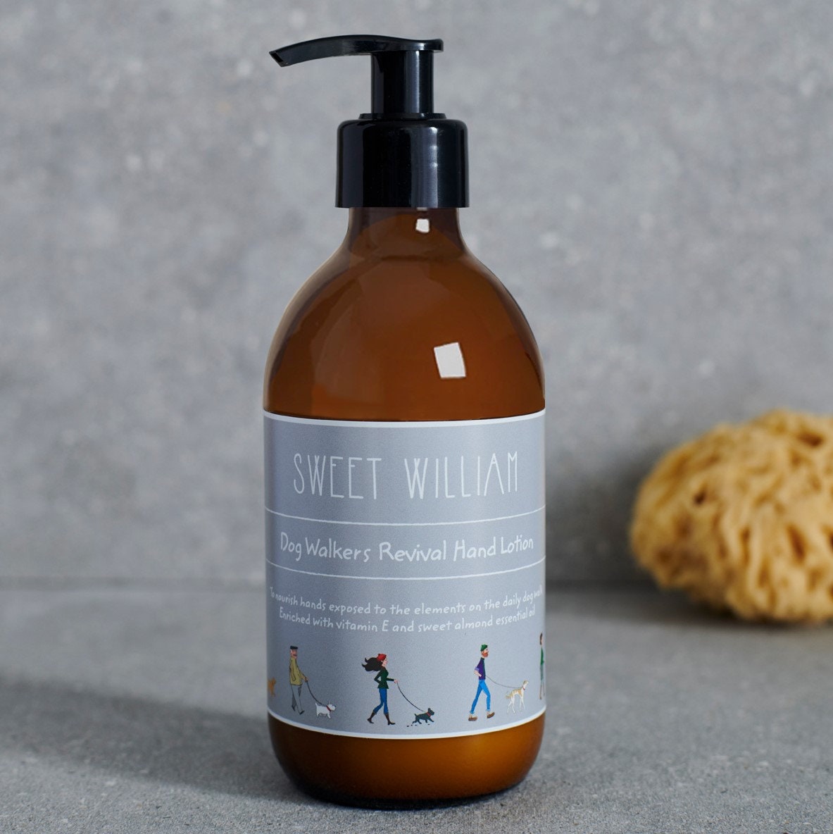 Close-up of Dog Walkers Revival Hand Lotion label in amber glass pump bottle — enriched with vitamin E and sweet almond essential oil, dog walker gift by Sweet William Designs