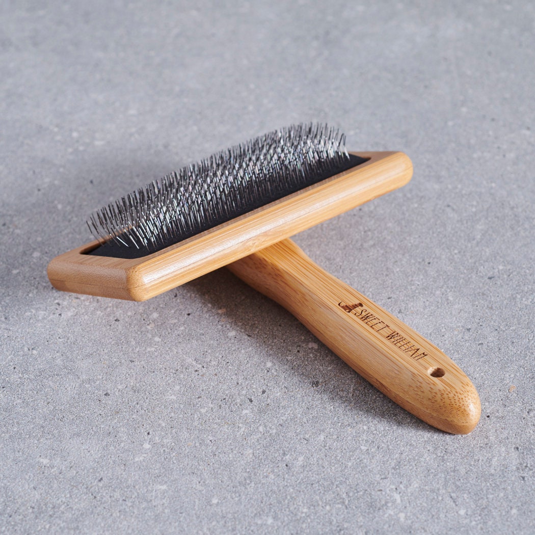 Bamboo slicker brush on grey stone surface — dog grooming brush by Sweet William Designs