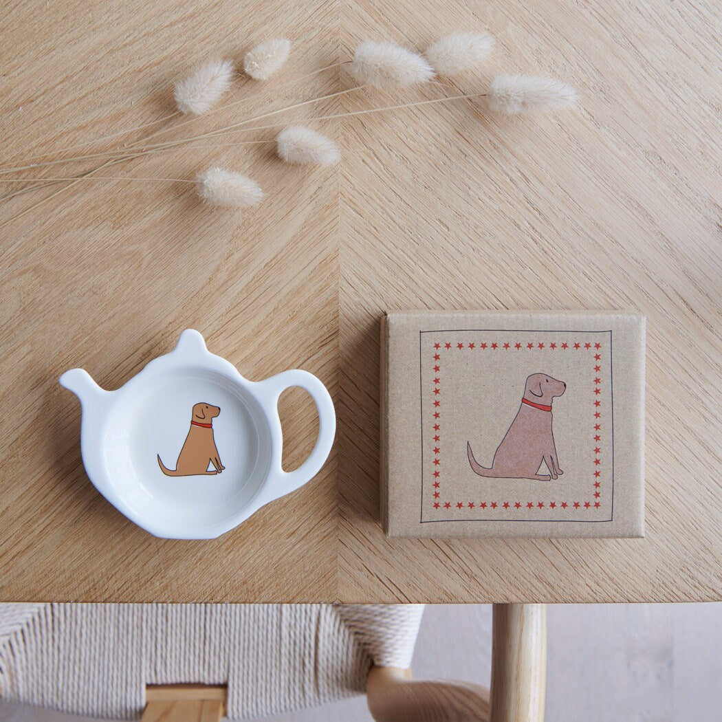 White teapot-shaped Fox Red Lab teabag dish beside its kraft gift box, both featuring a Labrador illustration with a red collar