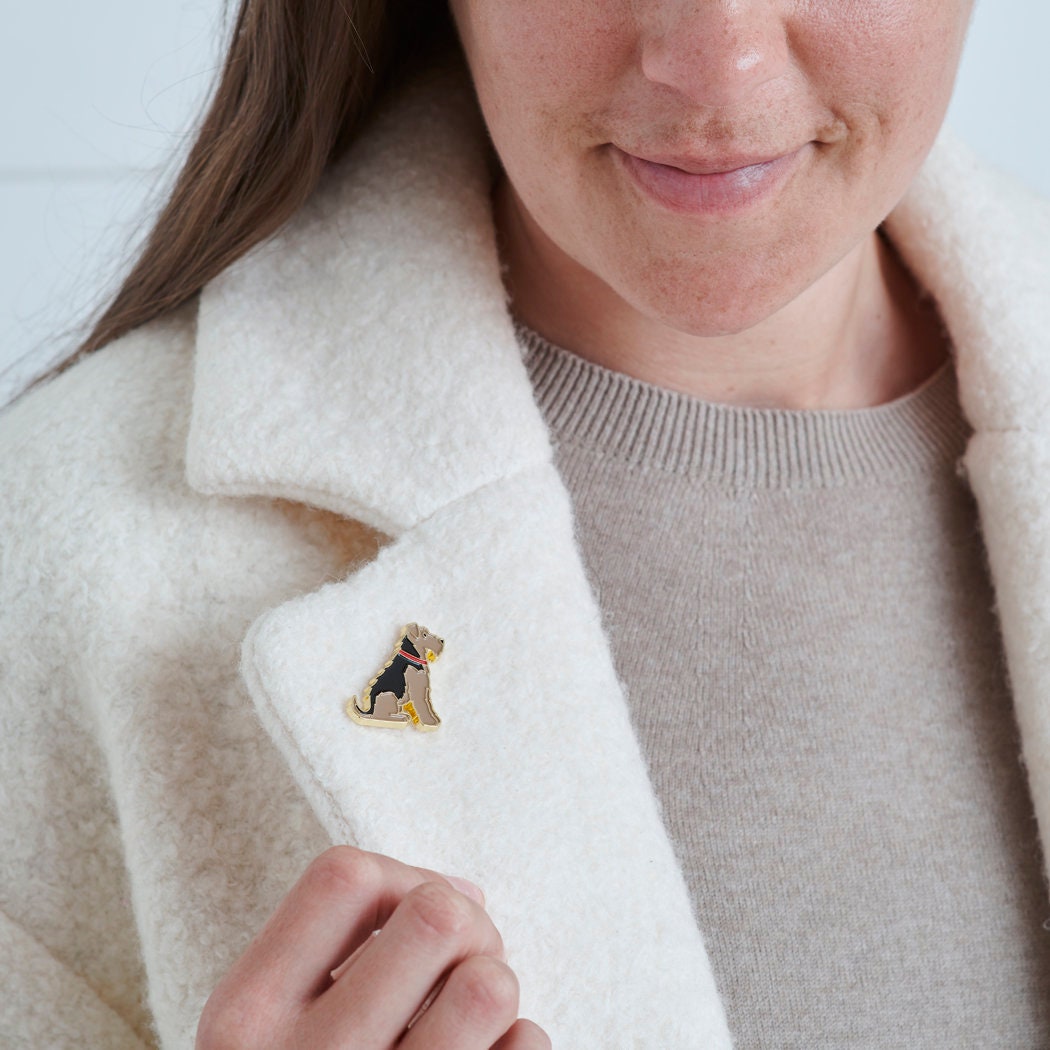 Close-up of Airedale / Lakeland / Welsh Terrier enamel pin being attached to a wool jacket collar — gold-plated dog lover gift by Sweet William Designs