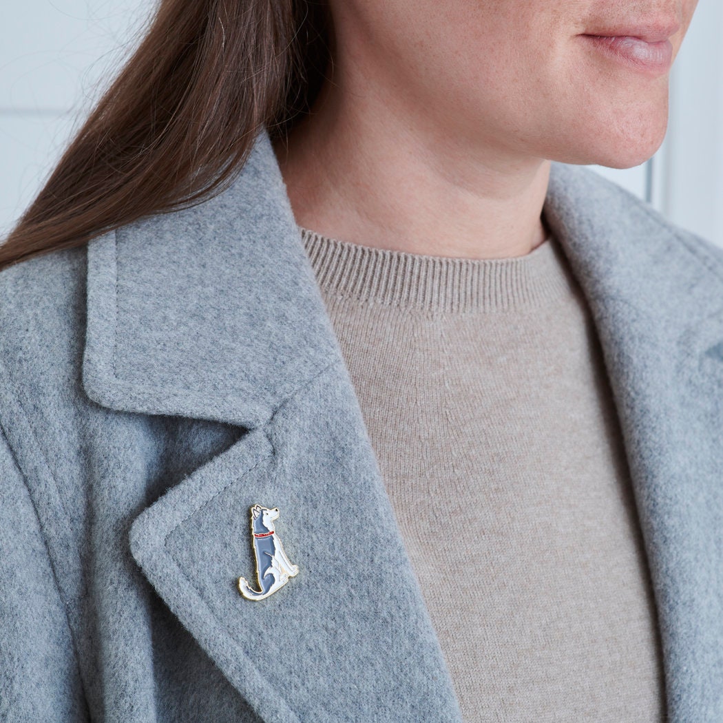 Husky / Alaskan Malamute enamel pin styled on the collar of a wool jacket, designed by Sweet William Designs