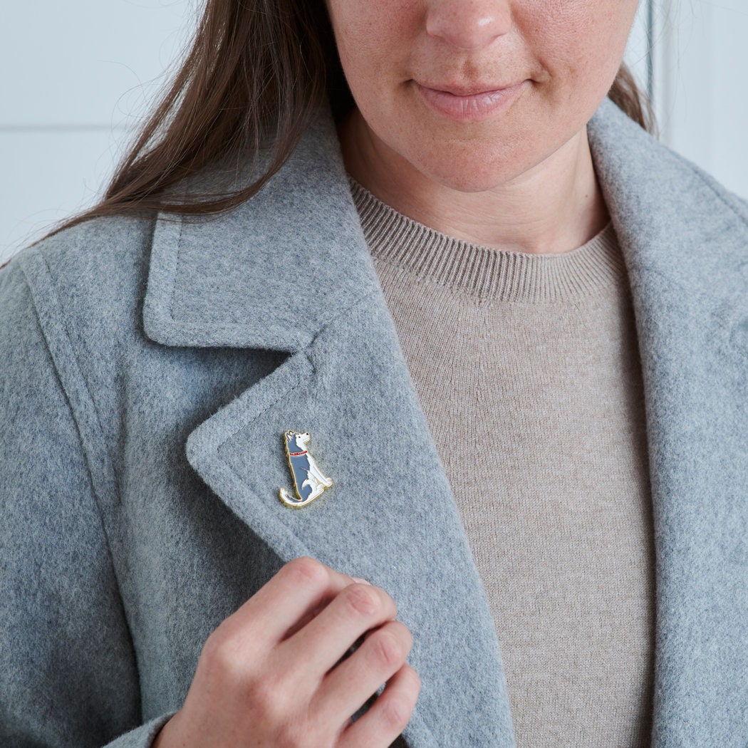 Husky / Alaskan Malamute enamel pin fastened to wool jacket collar, showcasing the detailed dog design by Sweet William Designs