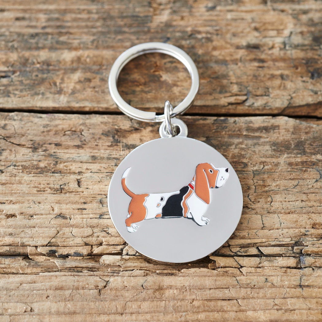 Close-up of Basset Hound dog ID tag — silver-plated brass with illustrated Basset Hound design, personalised dog tag by Sweet William Designs