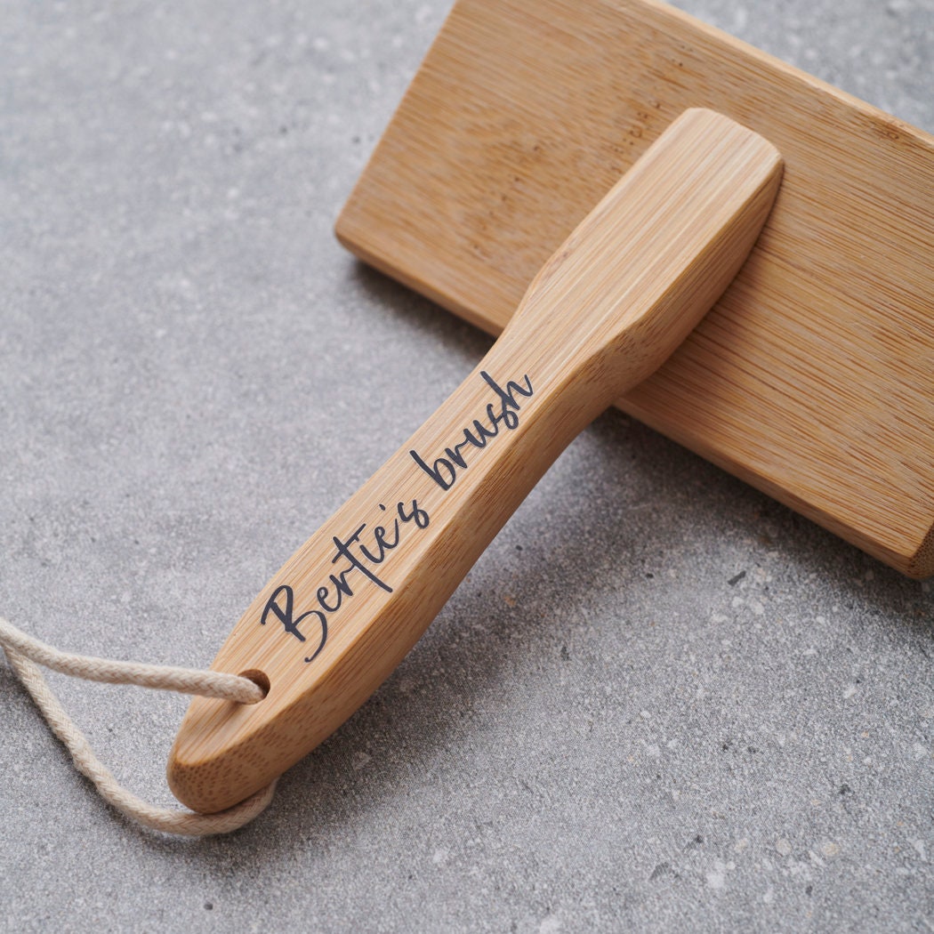Close-up of personalised bamboo slicker brush handle personalised with name of dog — dog grooming gift by Sweet William Designs
