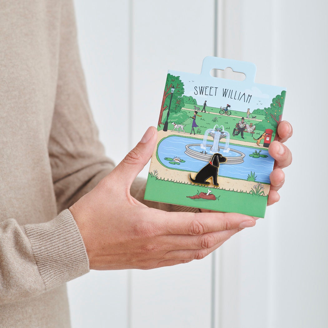 Black Cocker Spaniel enamel dog pin held in hands on illustrated park backing card — gold-plated dog lover gift by Sweet William Designs