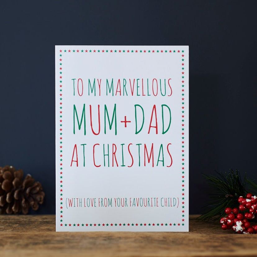 Funny Mum and Dad Christmas card with a cheeky favourite child message, festive red and green lettering and a colourful star border
