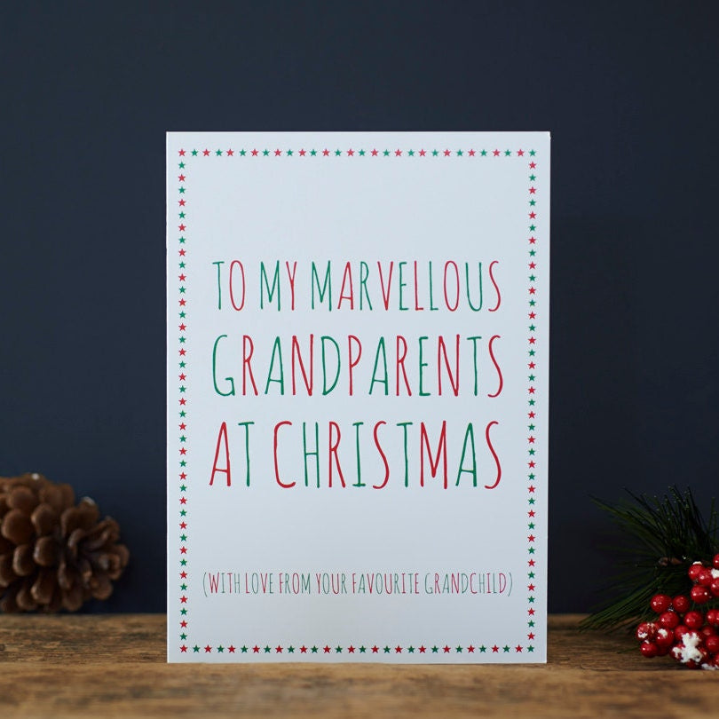 Funny Christmas card for Grandparents reading “To My Marvellous Grandparents at Christmas” with love from their favourite grandchild, styled with pine cones and red berries on a wooden table
