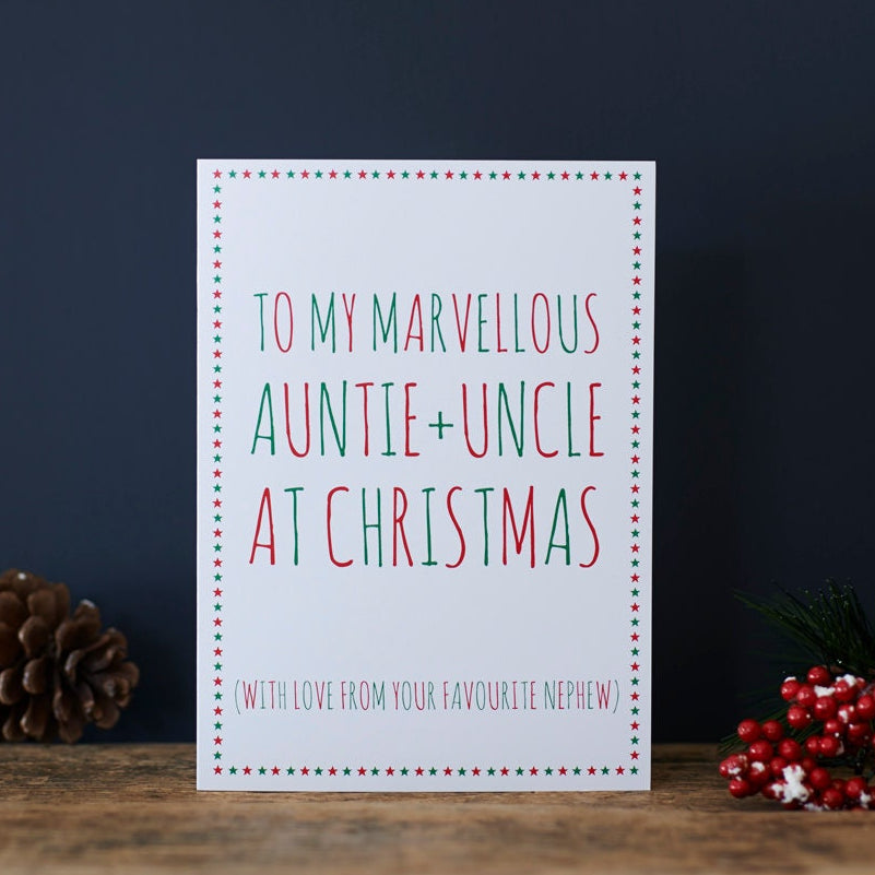Auntie and Uncle Christmas card with red and green lettering, a star border and “With love from your favourite nephew”, beside a pine cone and red berries.
