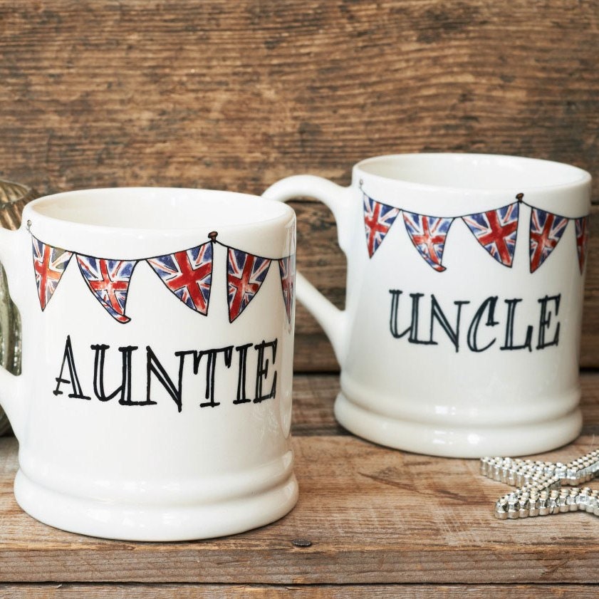 Ceramic Auntie and Uncle mugs with Union Jack bunting, photographed together on a rustic wooden surface, lovely family gift by Sweet William Designs
