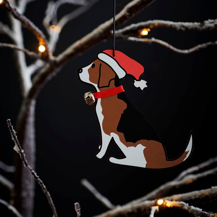 Beagle Christmas tree decoration hanging on lit winter tree — wooden dog decoration with Father Christmas hat and jingle bell collar by Sweet William Designs