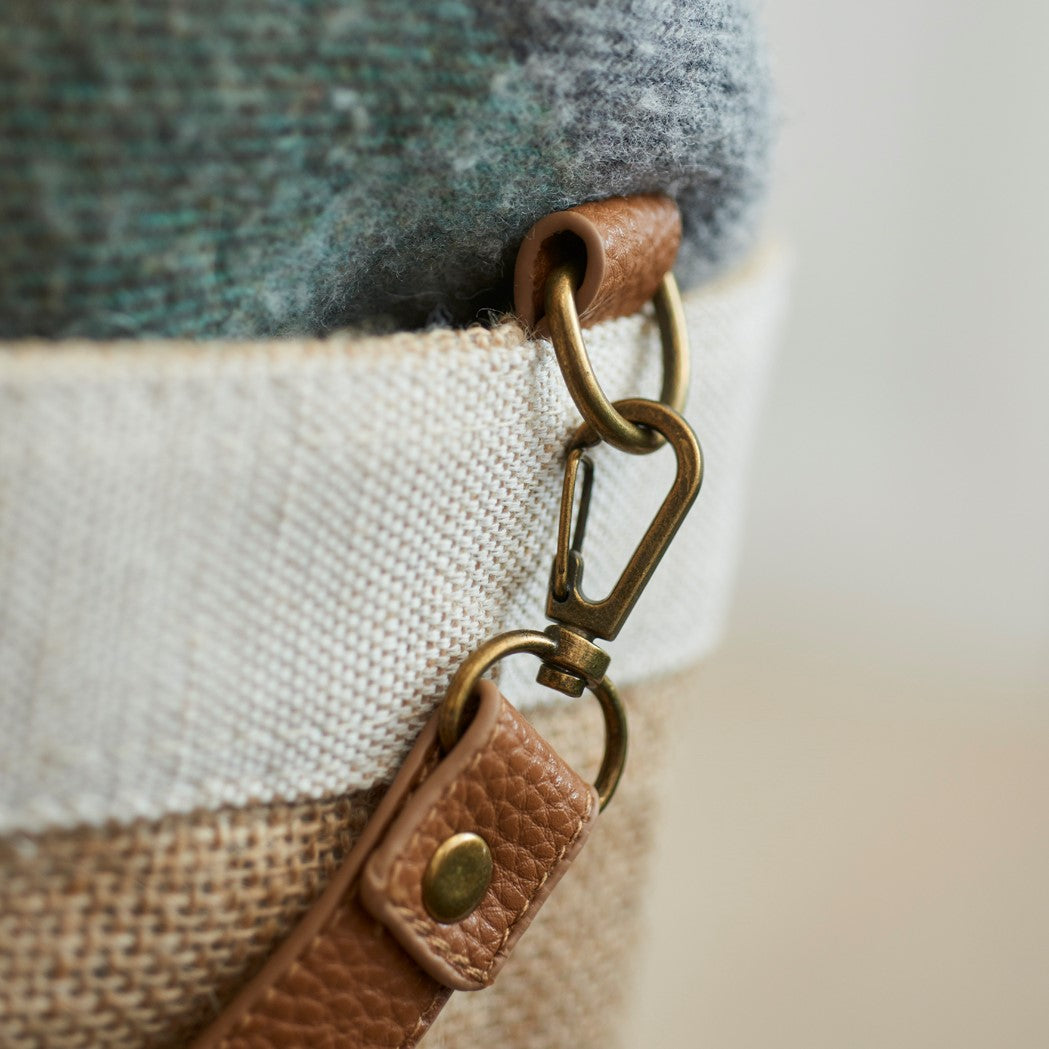 Close-up of tan leather strap and brass hardware on Sweet William jute bag — durable leather handles on natural jute tote