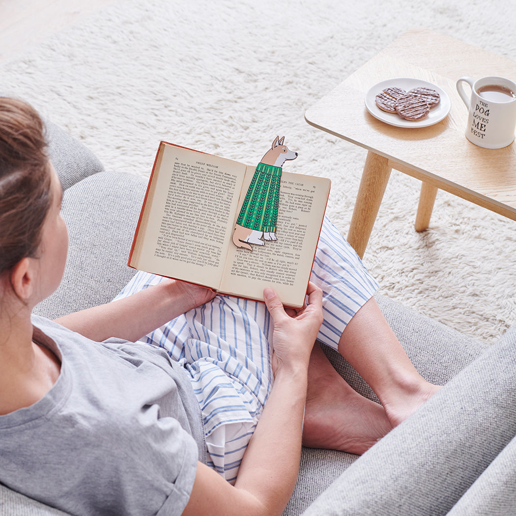 Woman reading a book with a Corgi bookmark and bestselling "The Dog Loves Me Best" mug by Sweet William Designs
