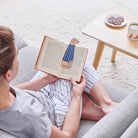 Woman reading a book with a Fox Red Labrador bookmark and matching Fox Red Labrador mug by Sweet William Designs