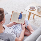 Woman reading a book with a Cavalier King Charles Spaniel bookmark and bestselling "The Dog Loves Me Best" mug by Sweet William Designs