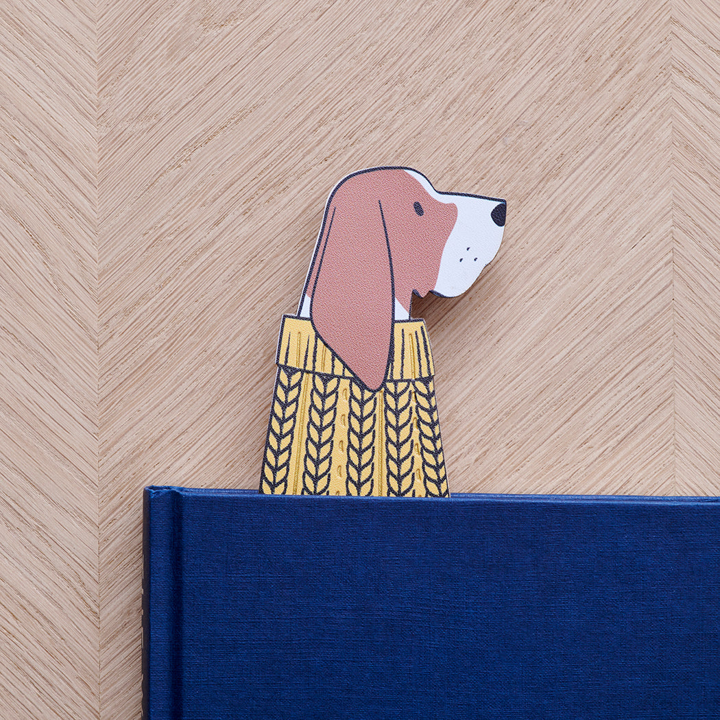 Basset Hound bookmark peeking out of navy book — illustrated dog in yellow jumper, vegan PU leather bookmark by Sweet William Designs