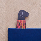 Black Labrador bookmark peeking out of navy book — illustrated dog in red jumper, vegan PU leather bookmark by Sweet William Designs