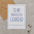 White Grandad card with blue lettering reading “To My Marvellous Grandad” and “With love from your favourite grandchild”, a blue star border, kraft envelope and silver cufflinks.